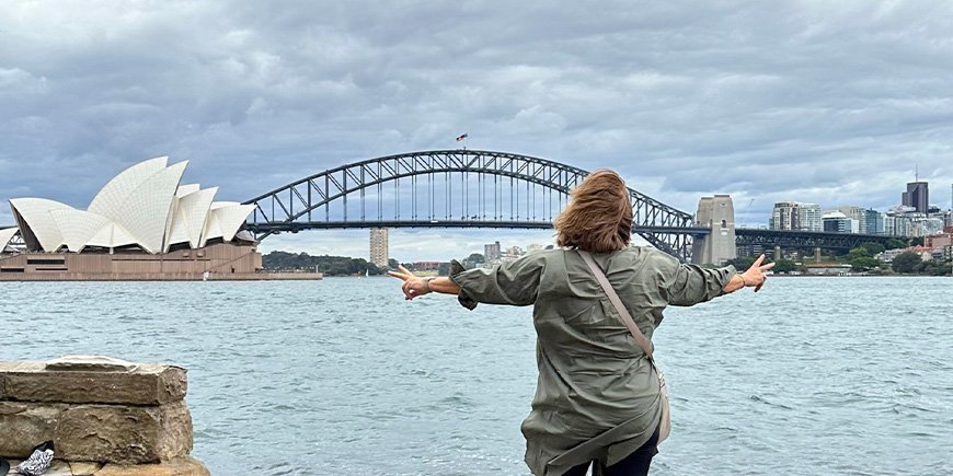 Beate seisoo oopperatalon ja Sydneyn satamasillan edessä Australiassa.