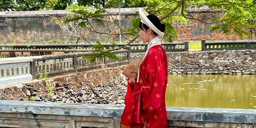 Kauniisti pukeutunut nainen keisarillisessa kaupungissa Hué Vietnamissa